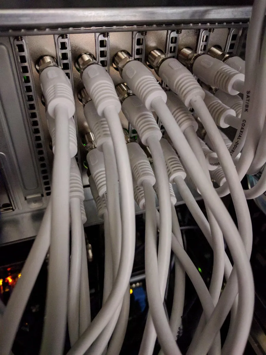 Foto der Rückseite eines 19" 4HE Servers mit vielen TV Karten die wiederum mit vielen Koaxialkabeln verbunden sind