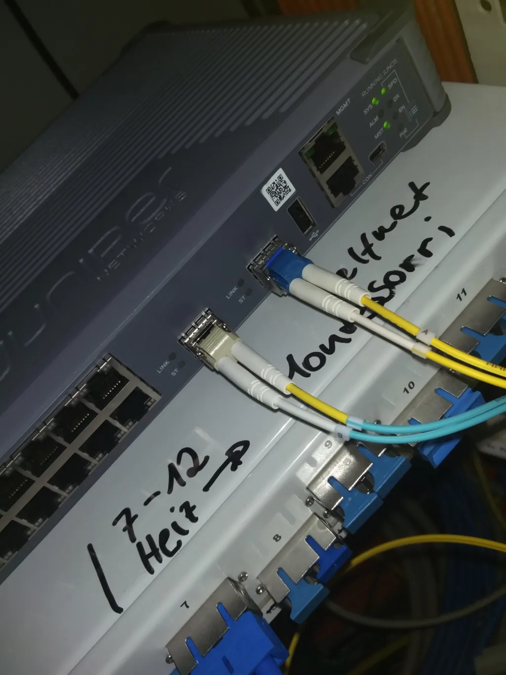 Foto von Medienkonverter (Juniper EX2300 Switch) in der PH mit dem ein Multimode Faserpaar und ein Singlemode Faserpaar verbunden ist.