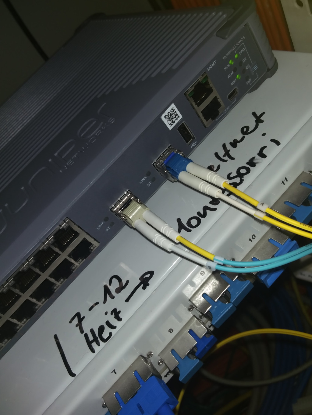 Foto von Medienkonverter (Juniper EX2300 Switch) in der PH mit dem ein Multimode Faserpaar und ein Singlemode Faserpaar verbunden ist.