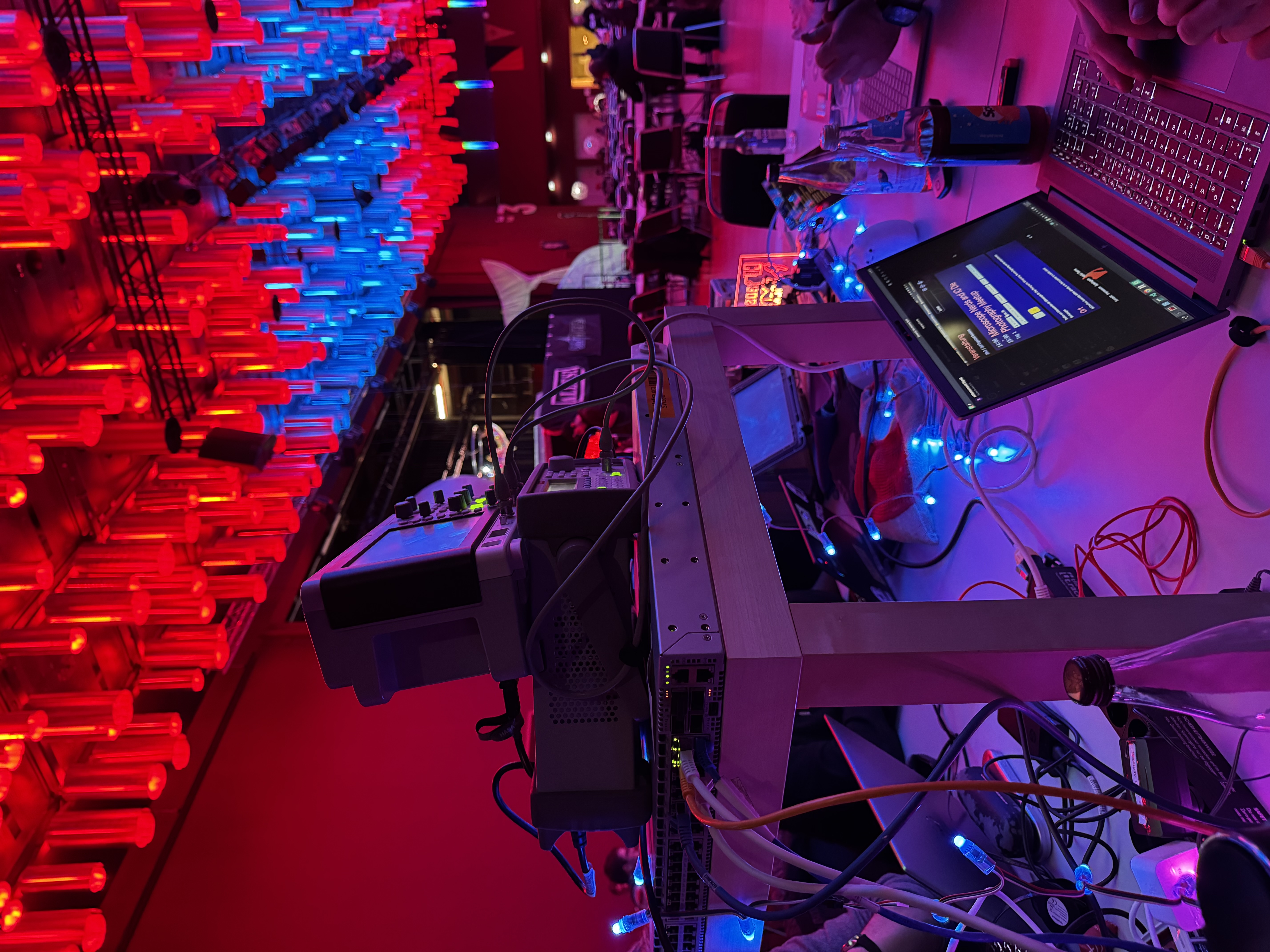 Measurement equipment on a table, a laptop in the foreground, and the ceiling of one of the Chaos Communication Congress halls behind it in the background